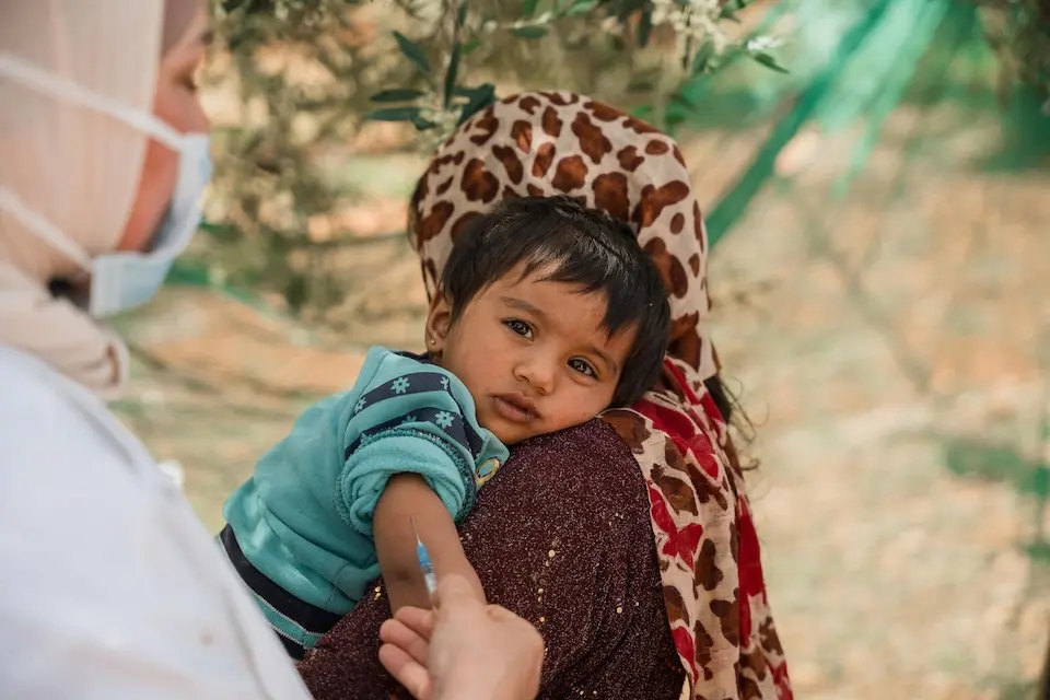 An 8-month-old is vaccinated by a UNICEF-supported vaccinator in the informal tented settlement in Jarish, north Jordan.