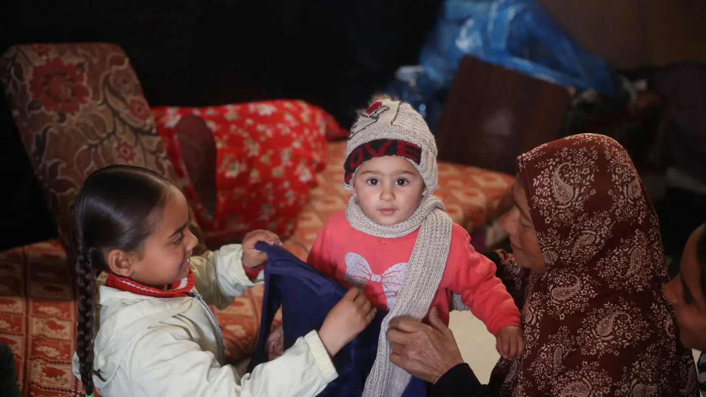 Family sitting together looking through winter clothing
