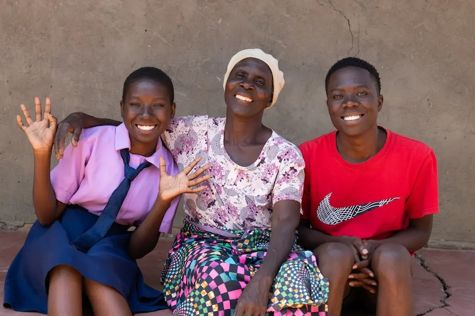 A 16-year-old K.I.N.D. Fund scholarship recipient, far left, with her grandmother and brother in Malawi. 