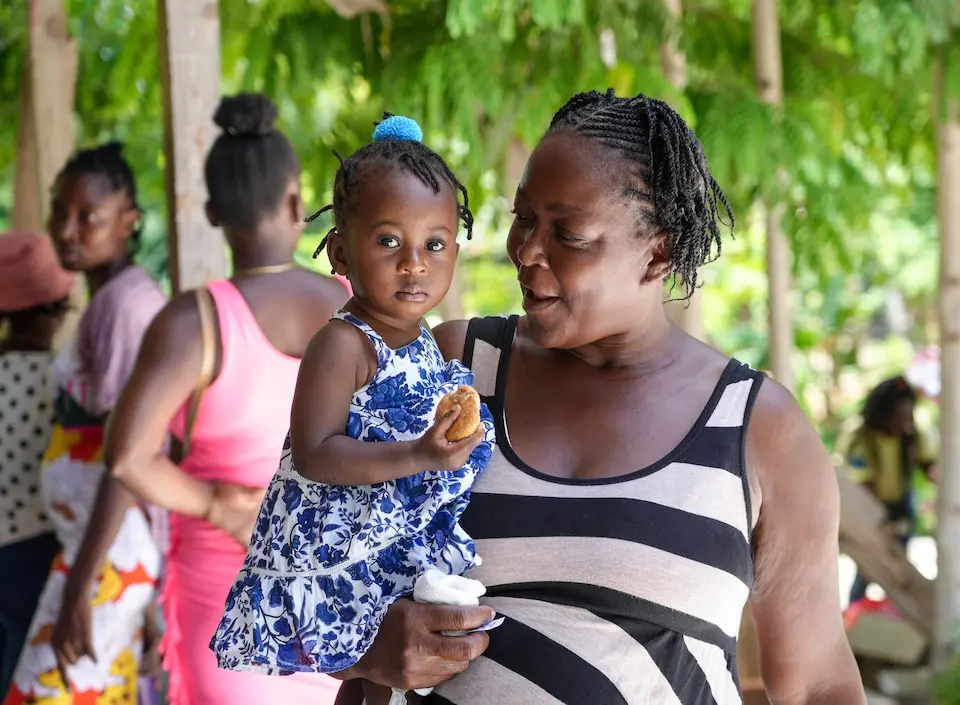 A woman holds her thirteen-month-old grandaughter at a UNICEF-supported mobile health and nutrition clinic in Boucan Carré, Haiti.