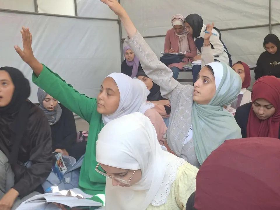 Students raise their hands to answer a teacher's question in a UNICEF learning space in Deir al-Balah, Gaza on Oct. 30, 2025.