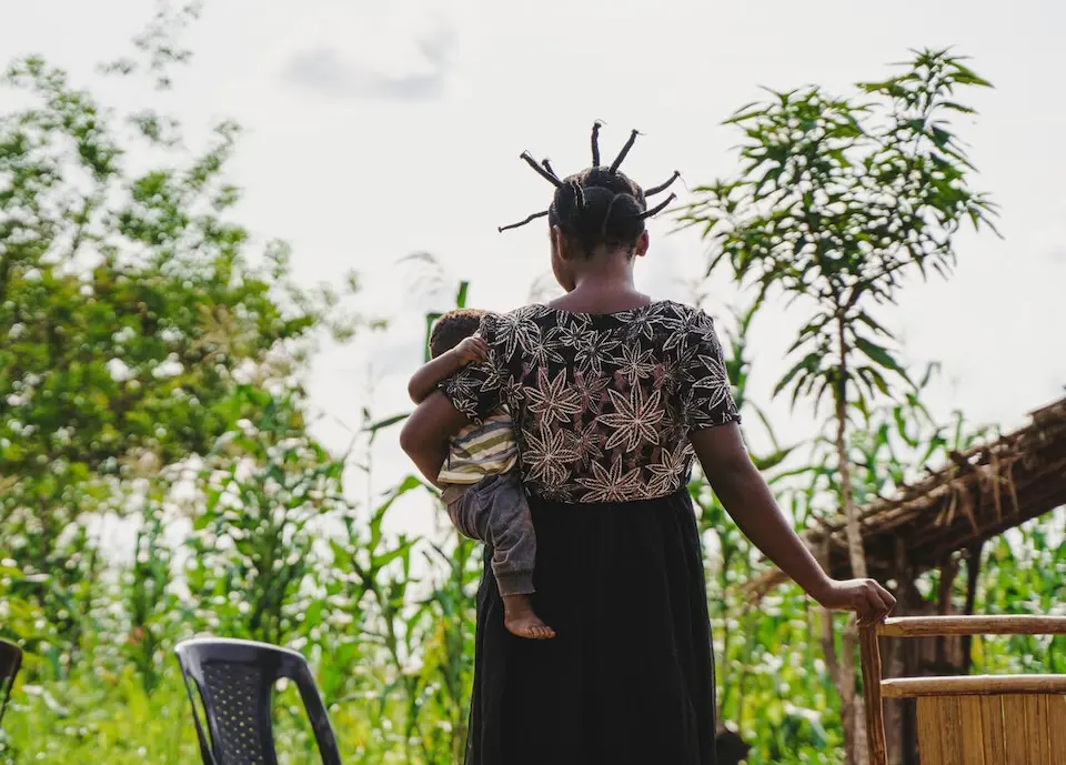 A mother of two holds her six-month-old baby outside their home in a village a village near Kananga, Kasai-Oriental province, DR Congo.