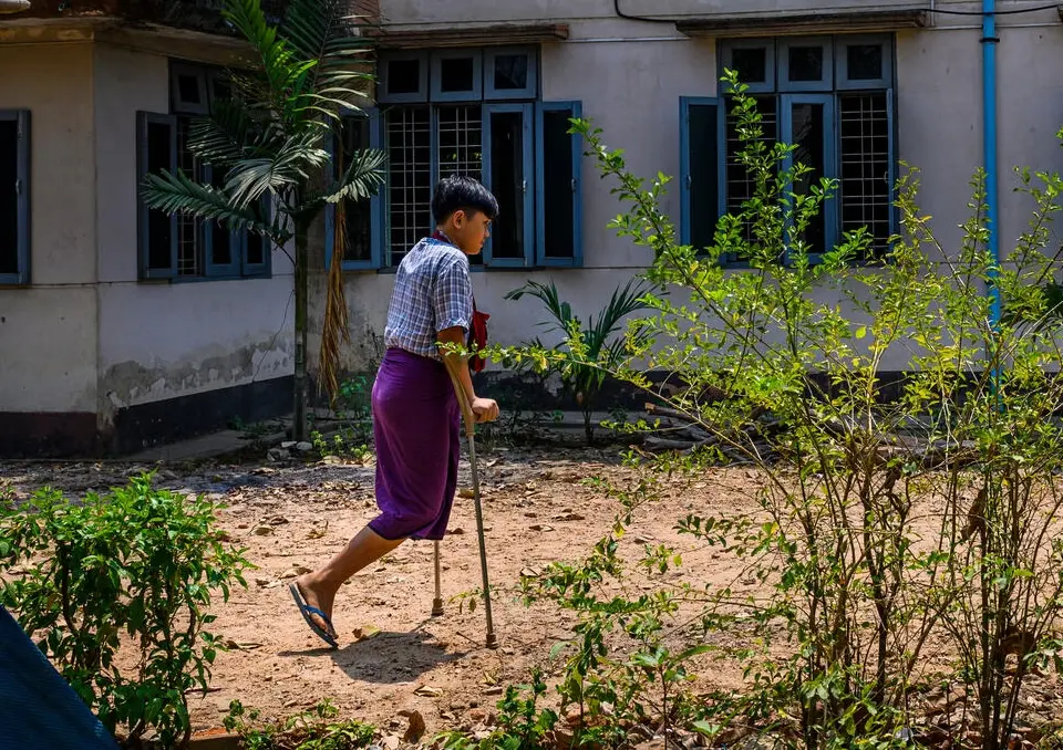 Fifteen-year-old landmine survivor Min Htet walks on crutches in Myanmar. 