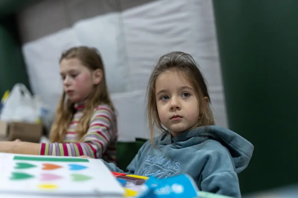 Four-year-old Mila plays with modeling clay at an emergency warming point in Kyiv, Ukraine.
