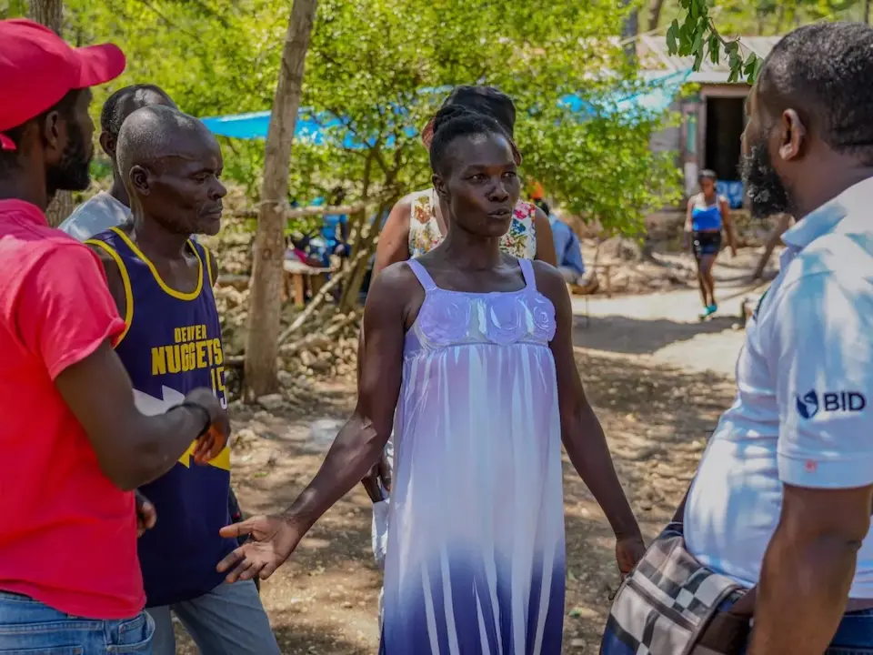 Oriata of Grand-Goave, Haiti, talking to neighbors about local sanitation and hygiene needs.