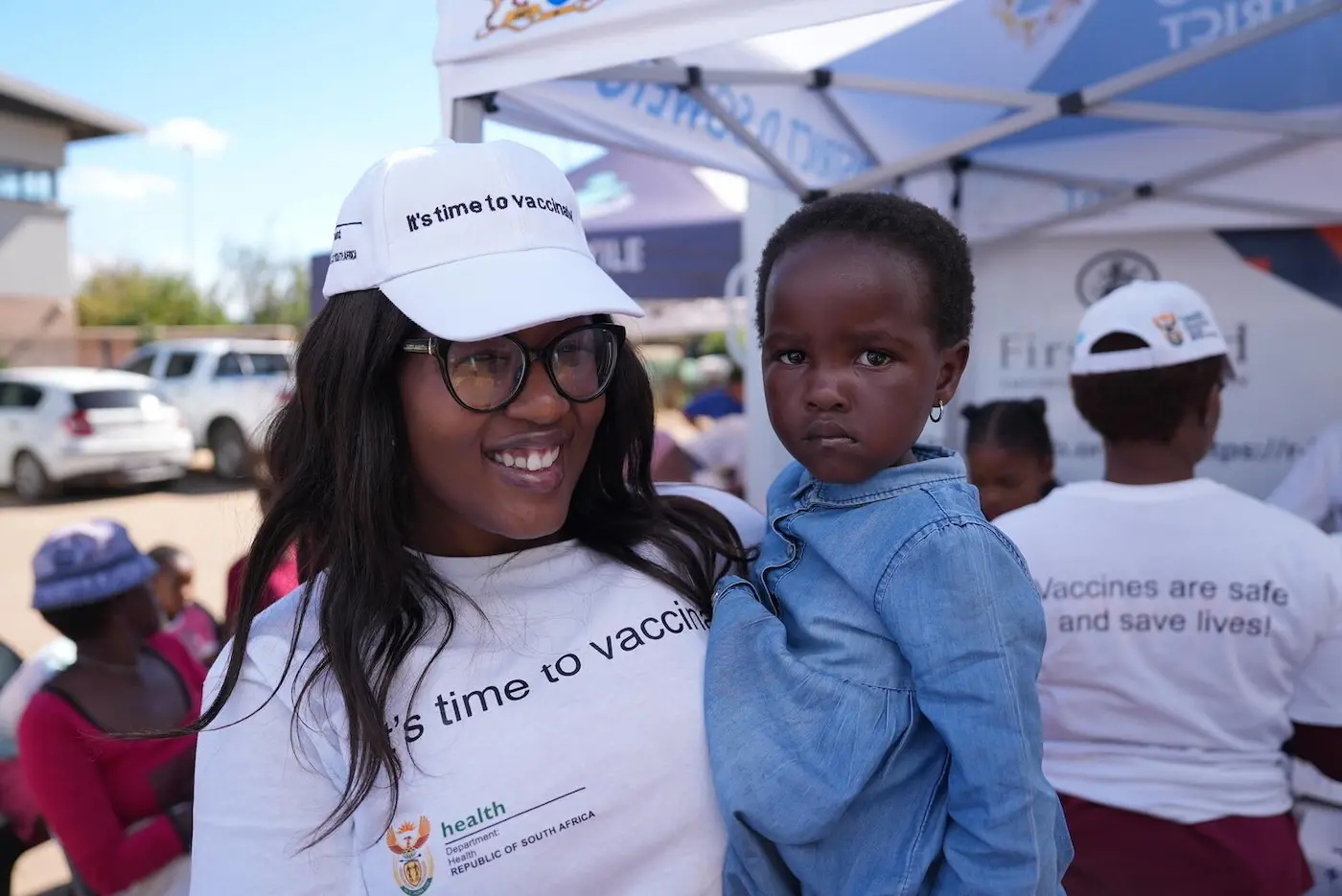 Health Officer at UNICEF South Africa, chats with a young girl before her routine immunization.