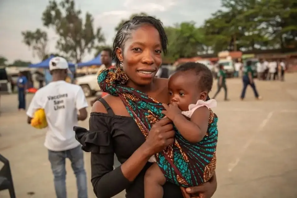 A mother in Zambia holds her child who has just received a malaria vaccination.