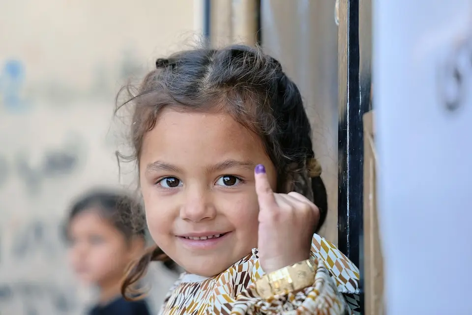A 4-year-old girl in Herat, Afghanistan, shows off her marked pinky showing she has been vaccinated for polio.