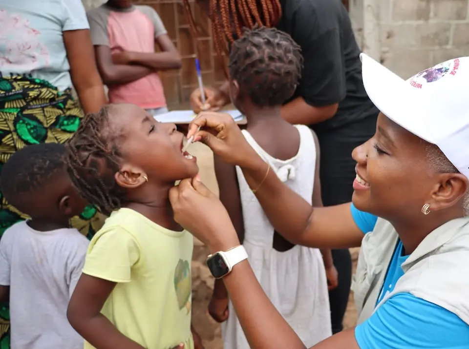 A girl in Mozambique receives the cholera vaccine from a UNICEF-supported health worker. 
