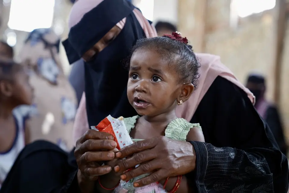 An 18-month-old girl is fed ready-to-use therapeutic food by her mother at a UNICEF-supported displacement camp in Yemen.
