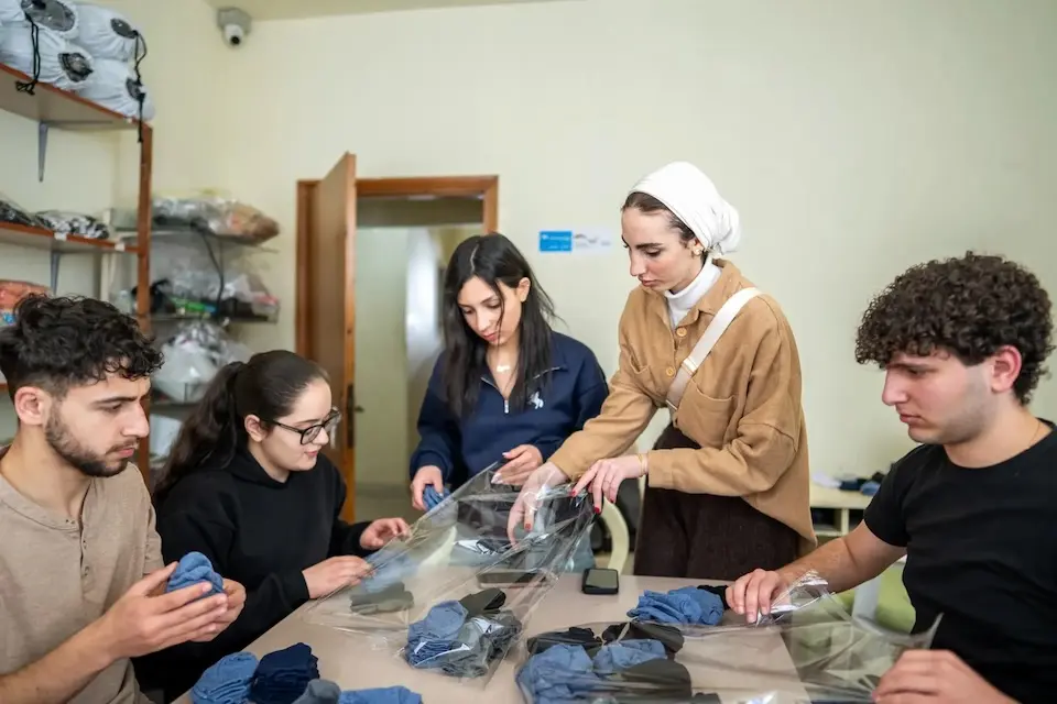 Youth in Lebanon prepare clothing kits for children living in temporary shelters. 