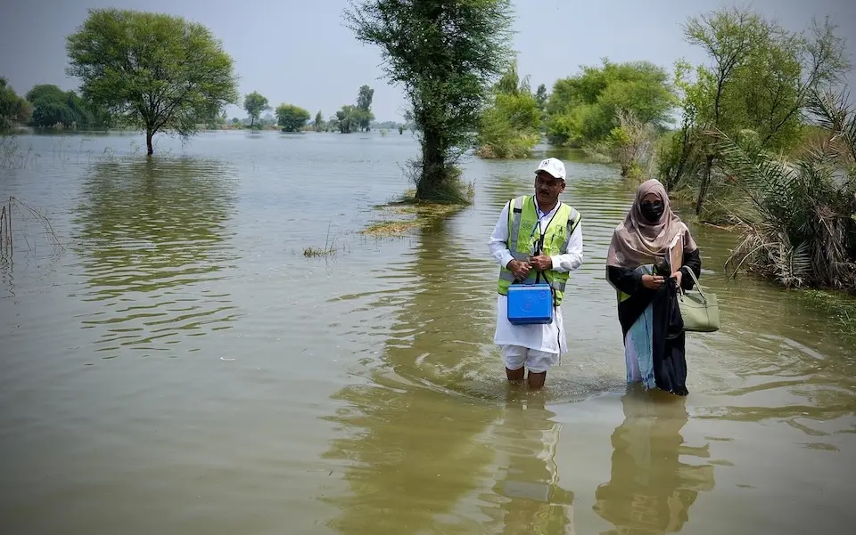 UNICEF-supported frontline workers wade through floodwaters to vaccinate children against polio in Dera Ghazi Khan, Pakistan on Sept. 2, 2025.