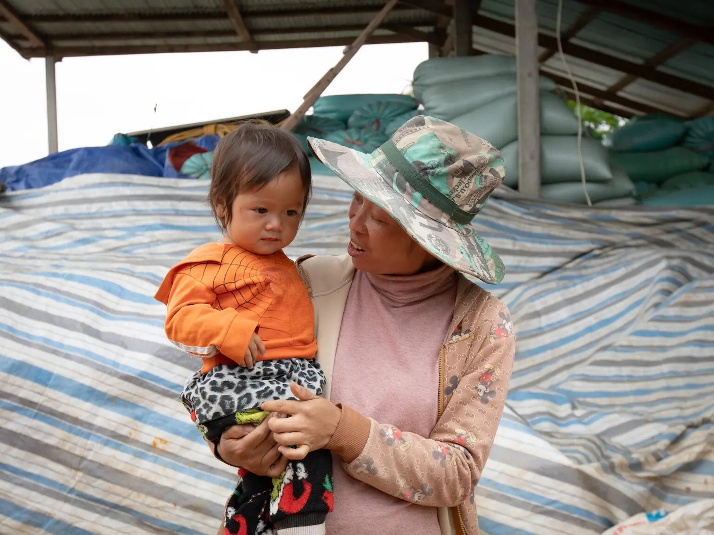 A mother holds her toddler daughter after receiving polio vaccination drops in Phou Hua Xang Village, Nonghat District, Xiengkhouang Province, Laos. 