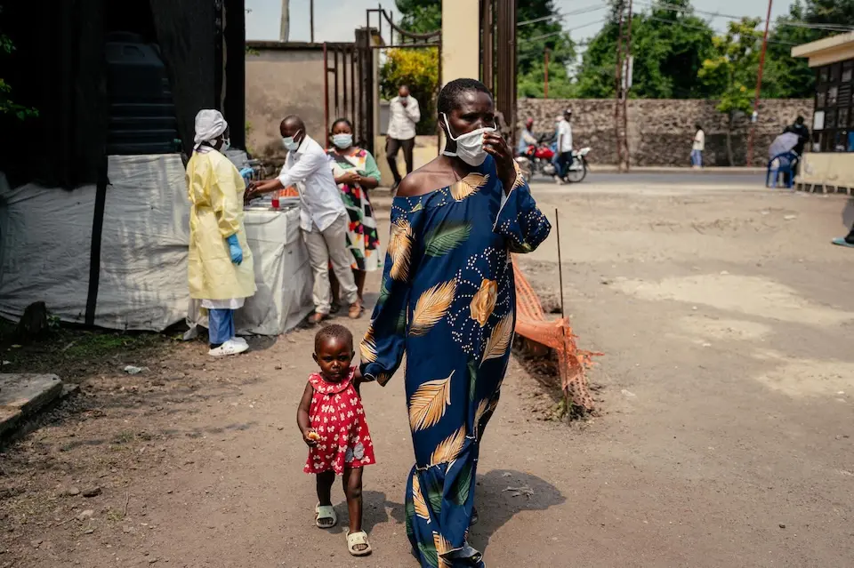 A woman walks holding a young child's hand in Goma, DR Congo.