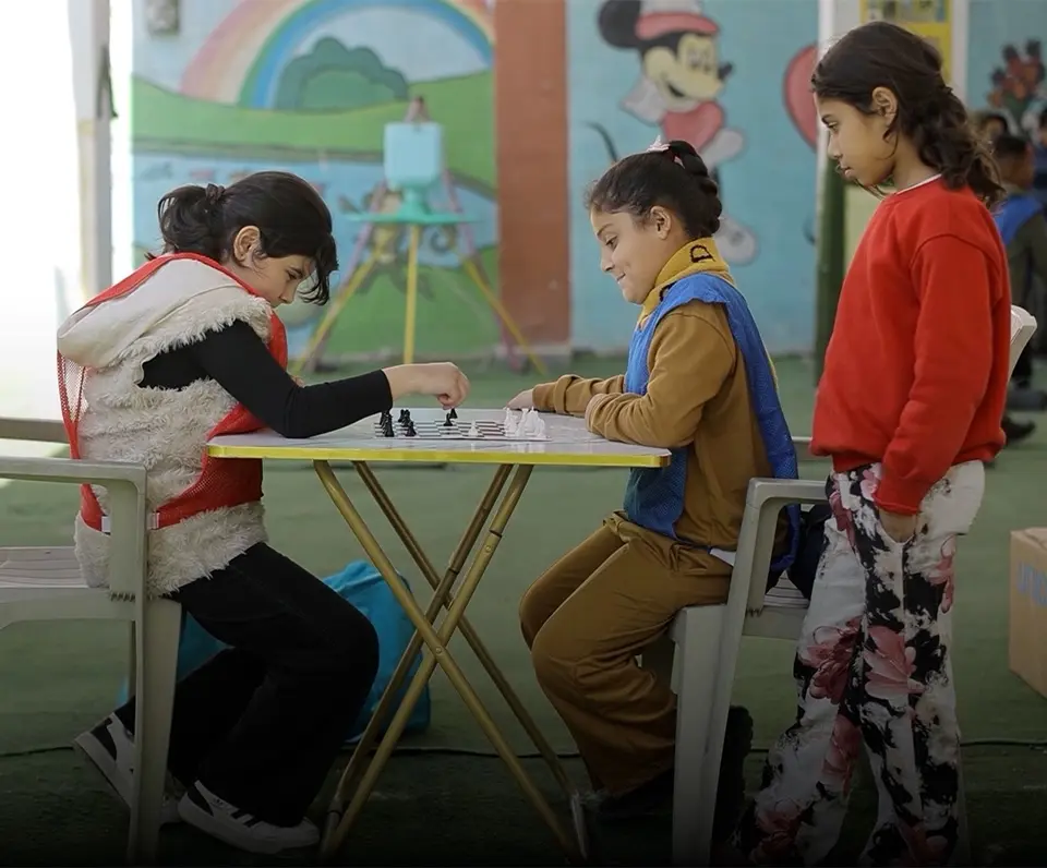 Children play chess in a UNICEF-supported child-friendly space in the Gaza Strip. 