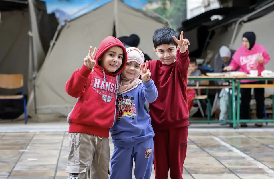 A group of children stand in front of a tent in a UNICEF-supported displacement site in Lebanon in 2026.