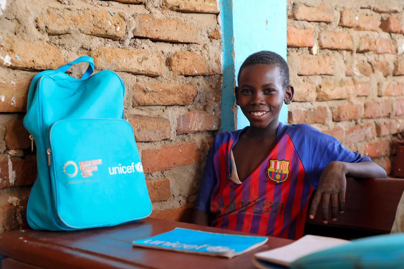 TOP PHOTO: Ayman Adam, 12, sits in a classroom at Al Imtidad School, supported by UNICEF, in Farchana, eastern Chad with a UNICEF-provided backpack full of supplies to help him learn. 