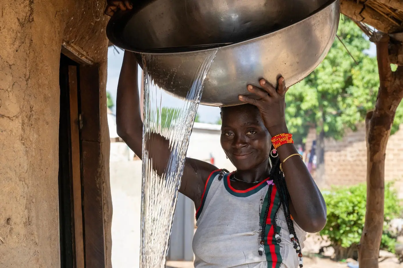 A girl carries water in the village of Fatonvogo, in northern Côte d'Ivoire, have access to safe drinking water through a newly installed water pump. UNICEF supports sustainable water supply systems to ensure children and their families can access safe water close to home. 