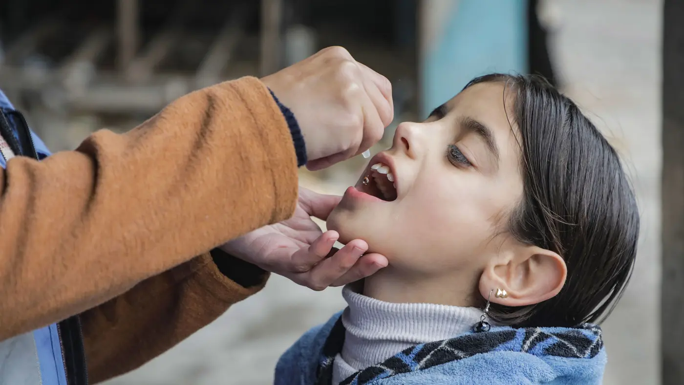 Young girl being given an oral vaccine