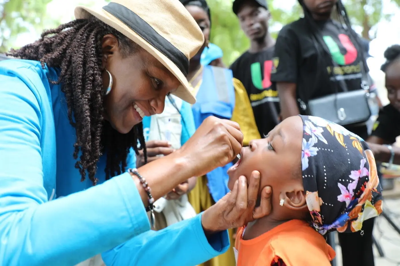 UNICEF's Representative in Cameroon smiles while giving the oral polio vaccine to a young child in the Far North region.