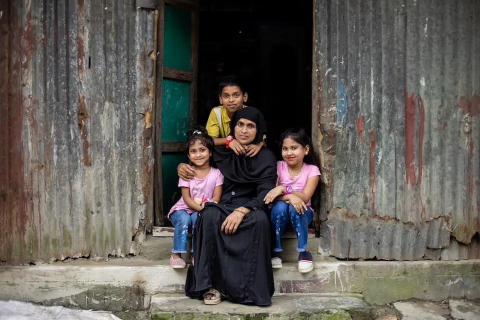 A mother and children sit in the doorway of their house in Kishoreganj, Bangladesh. 