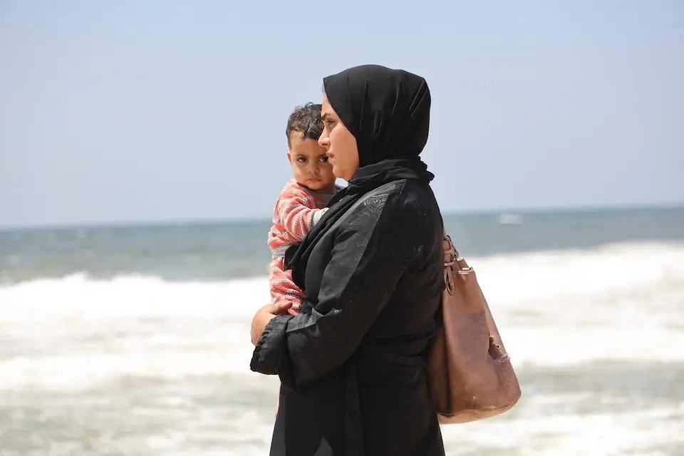 A Palestinian mother holds her baby near the Mediterranean Sea. 