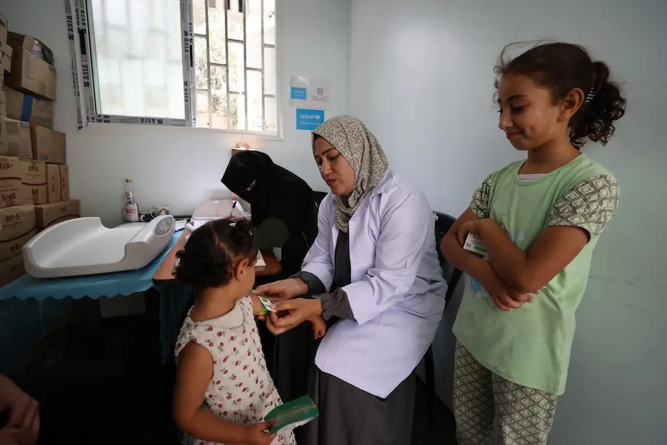 A health worker screens a child for malnutrition at a UNICEF-supported health center in Khan Younis, Gaza Strip. 