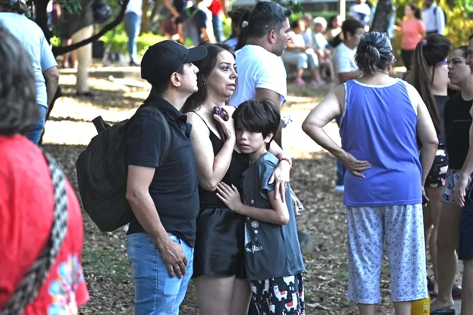 Families wait anxiously in a park in Cali after evacuating their homes following a major earthquake in Colombia. 