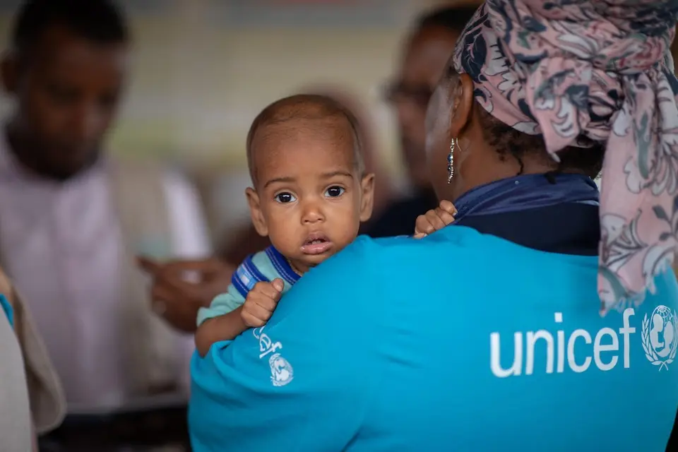 A UNICEF staff member holds a baby during a visit to the UNICEF-supported health and nutrition facility in Moqor iyo Mayow IDP settlement in Somalia on Aug. 5, 2026.
