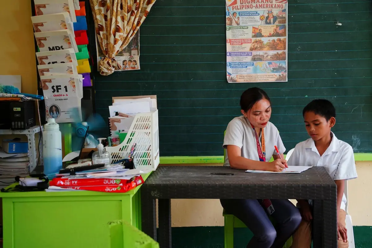 A teacher and student work together on an assignment in the Phillippines.