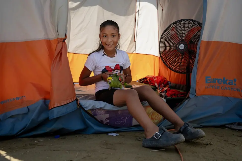 Derwinar in Venezuela with her parrot at the shelter for families displaced by the earthquake. 