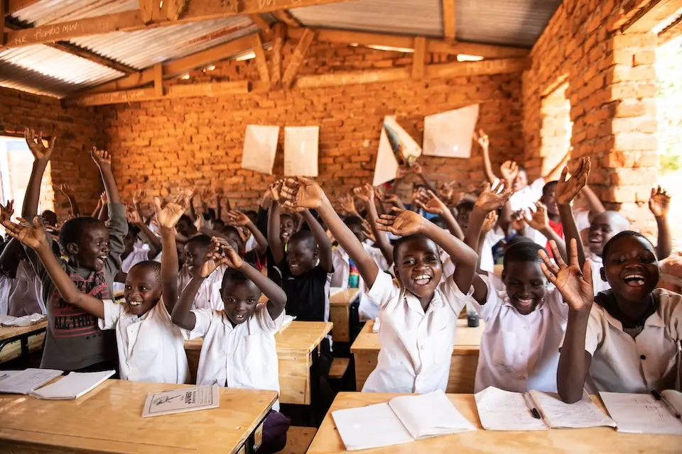 School children in Malawi celebrate the arrival of new desks from The K.I.N.D. Fund.