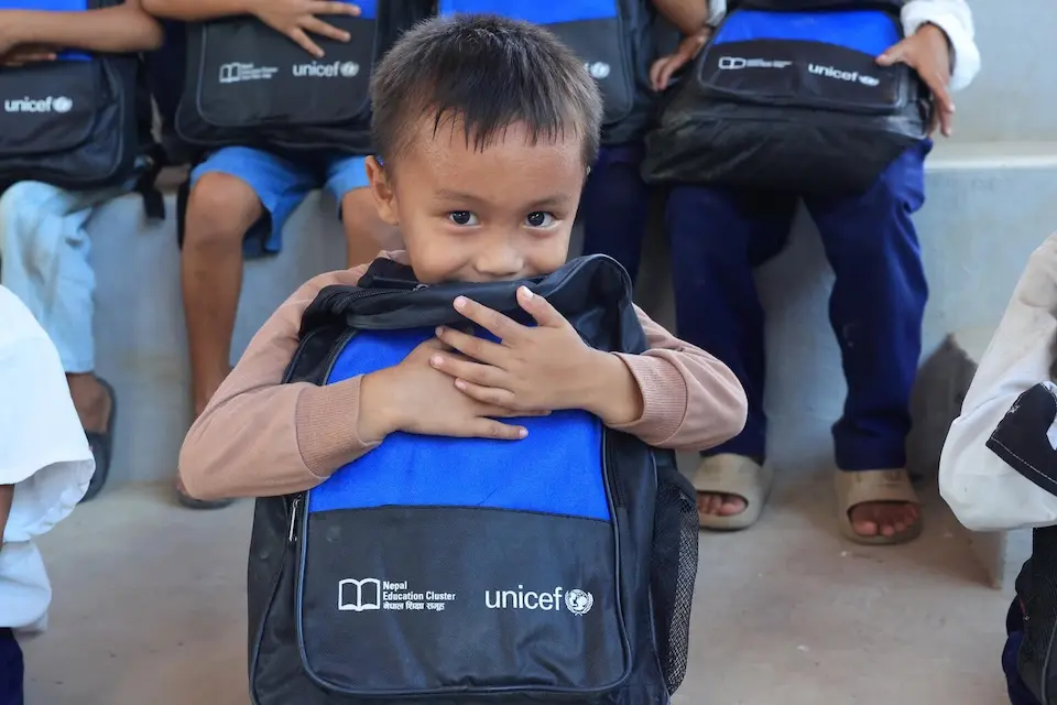 One month after devastating floods, a boy holds a new UNICEF backpack filled with school supplies in Nuwakot, Nepal.