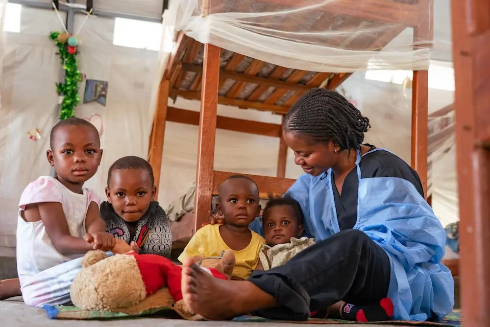 A caregiver with young children at a UNICEF-supported Ebola nursery in DRC.