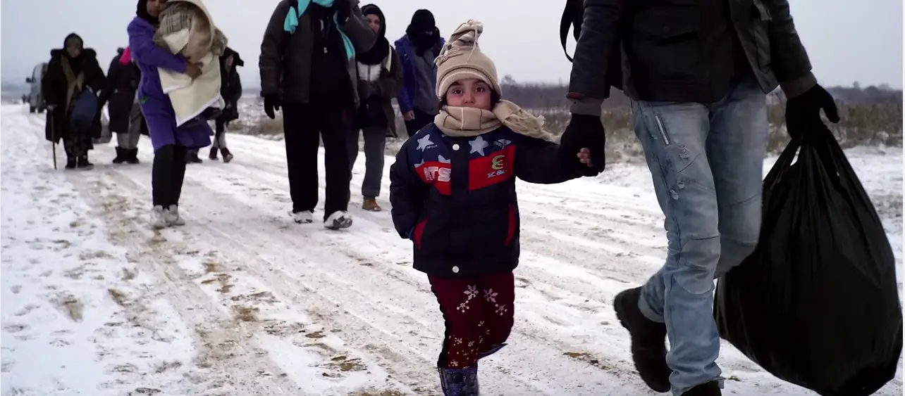 Migrant families trek through the snow in Syria.