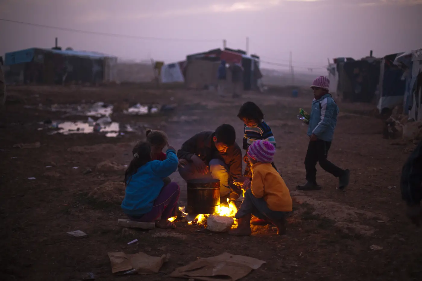 People Huddled By Fire