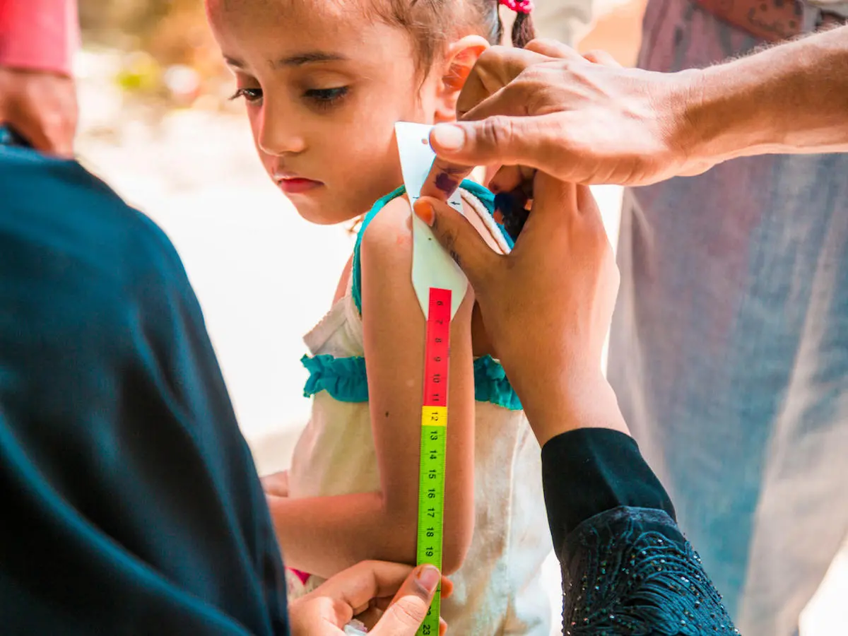 A child has her upper arm measured to screen for malnutrition as part of a door-to-door immunization campaign in Yemen in October 2017. A child has her upper arm measured to screen for malnutrition as part of a door-to-door immunization campaign in Yemen in October 2017.