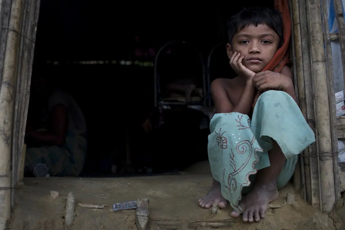Murium Begu, 7, sits by the entrance of her home in Chakmakul, a refugee camp sheltering over 800,000 Rohingya refugees, in Cox's Bazar, Bangladesh.