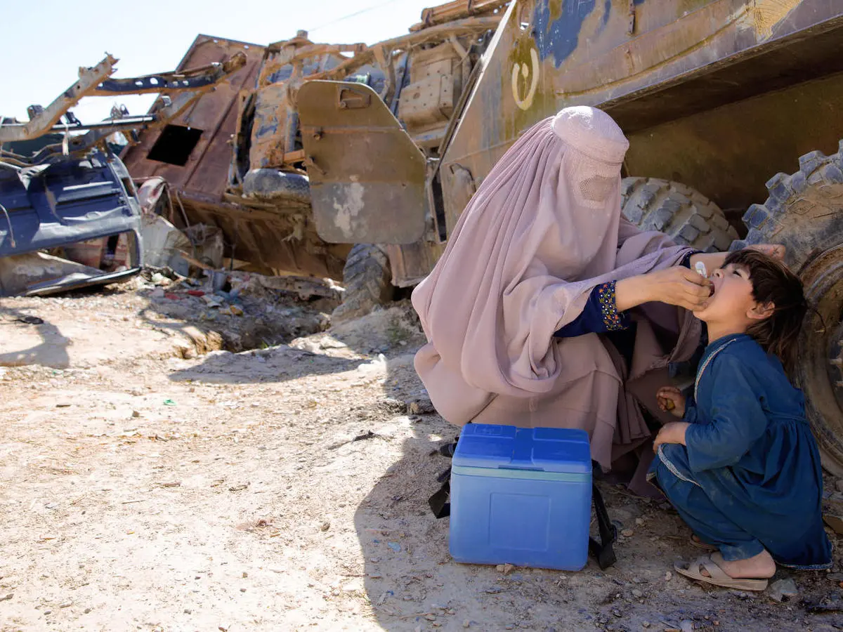 UNICEF-supported polio worker Afia (name changed), 19, vaccinates a child in an old military barrack in Afghanistan in March 2018. UNICEF-supported polio worker Afia (name changed), 19, vaccinates a child in an old military barrack in Afghanistan in March 2018.