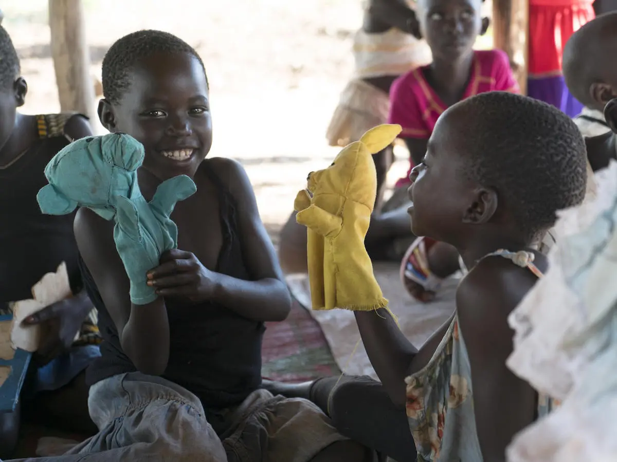 South Sudanese refugee children play with locally made hand puppets in Yumbe district, Uganda. South Sudanese refugee children play with locally made hand puppets in Yumbe district, Uganda.