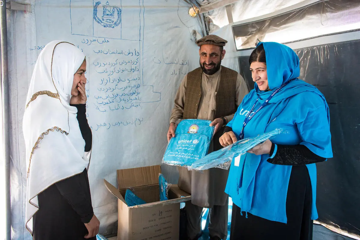 UNICEF Education Specialist Anita Haidary and colleague hand out school bags to an excited student at a UNICEF-supported school in Nangarhar, Afghanistan in 2019. UNICEF Education Specialist Anita Haidary and colleague hand out school bags to an excited student at a UNICEF-supported school in Nangarhar, Afghanistan in 2019.