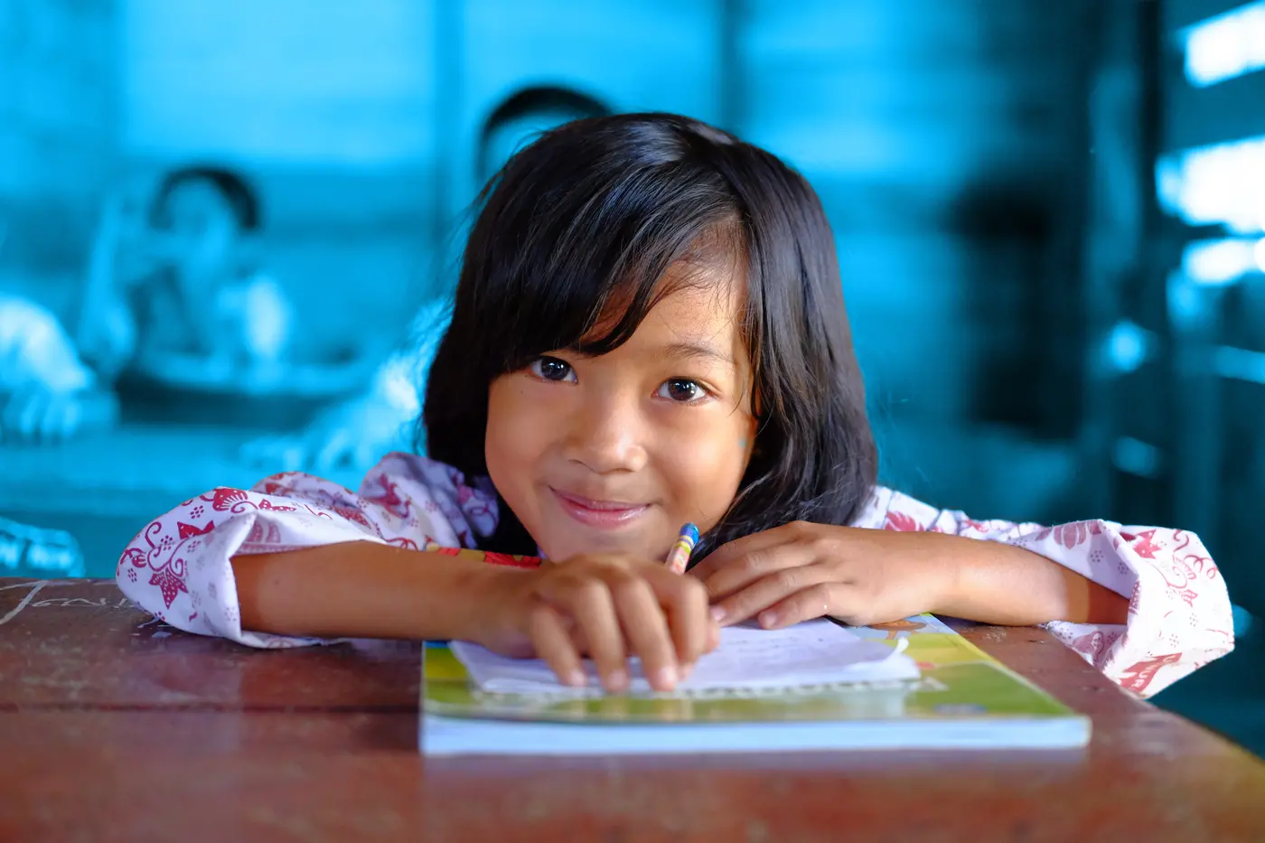 child smiling holding a book