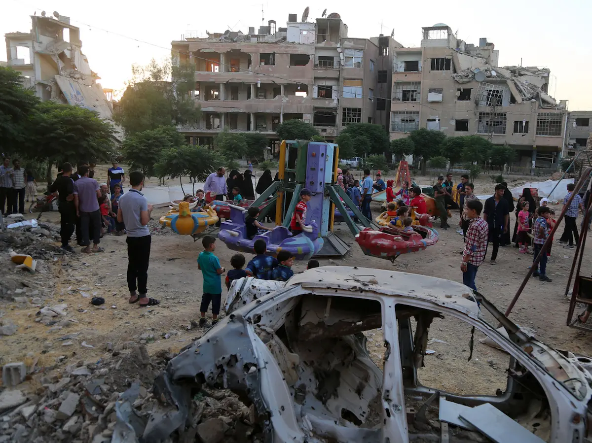 Children play at the Eid theme park as they celebrate Eid al-Fitr, which marks the end of Ramadan, in besieged East Ghouta, rural Damascus, Syrian Arab Republic, Sunday 25 June 2017. 