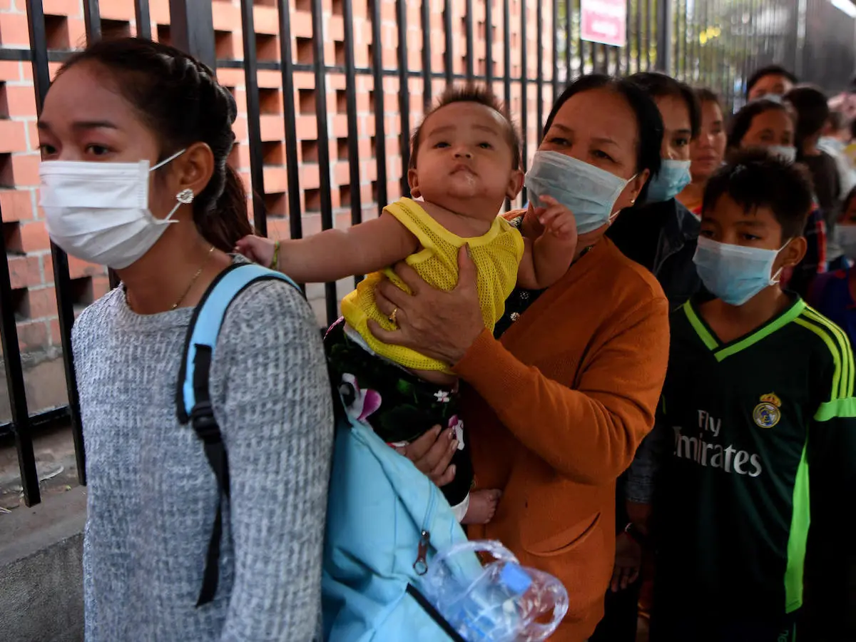 People wearing face masks line up to enter a children’s hospital in Phnom Penh, Cambodia on January 30, 2020 after the nation’s first case of novel coronavirus was reported.