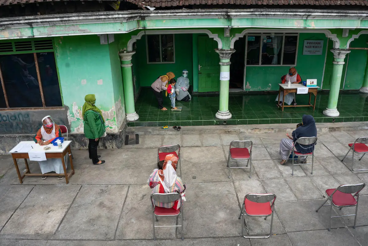 A child is weighed at a health post in Sidorejo village, Central Java province, Indonesia.