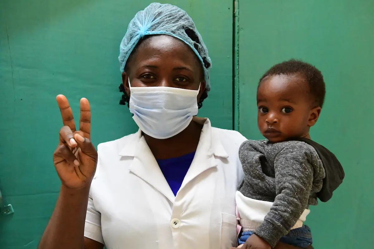 A nurse at Buéa Regional Hospital in Buéa, southwest Cameroon, flashes a "V for vaccinated" sign showing that she has received a coronavirus vaccine.