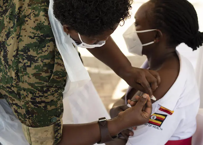 Baluka Winfred Viola, a Nursing Officer at Kisenyi Health Center IV, receives a shot of the AstraZeneca COVID-19 vaccine at Mulago National Referral Hospital during the official launch of  COVID-19 vaccination in Uganda.