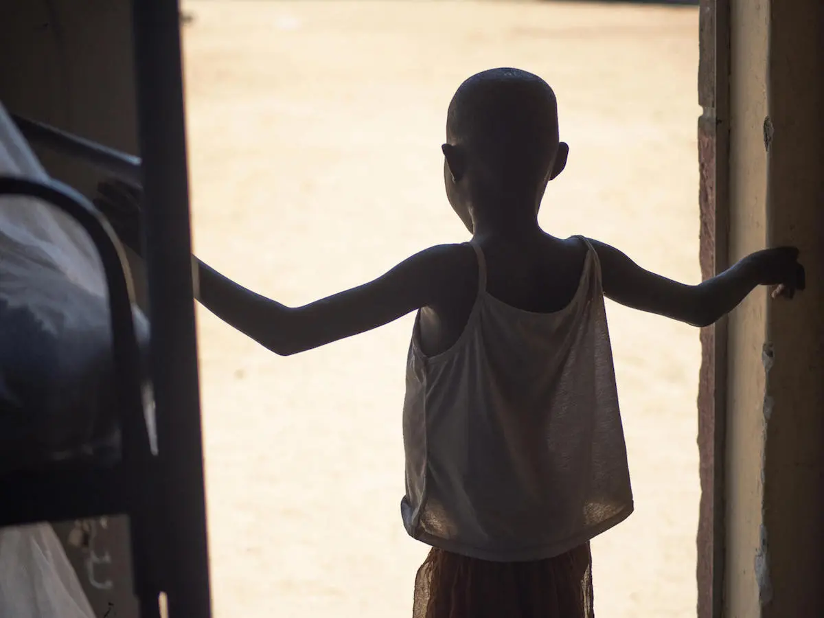 An 8-year-old girl rescued from female genital mutilation stands in a doorway at Kalas Girls Primary School in Uganda's Amudat District. An 8-year-old girl rescued from female genital mutilation stands in a doorway at Kalas Girls Primary School in Uganda's Amudat District.