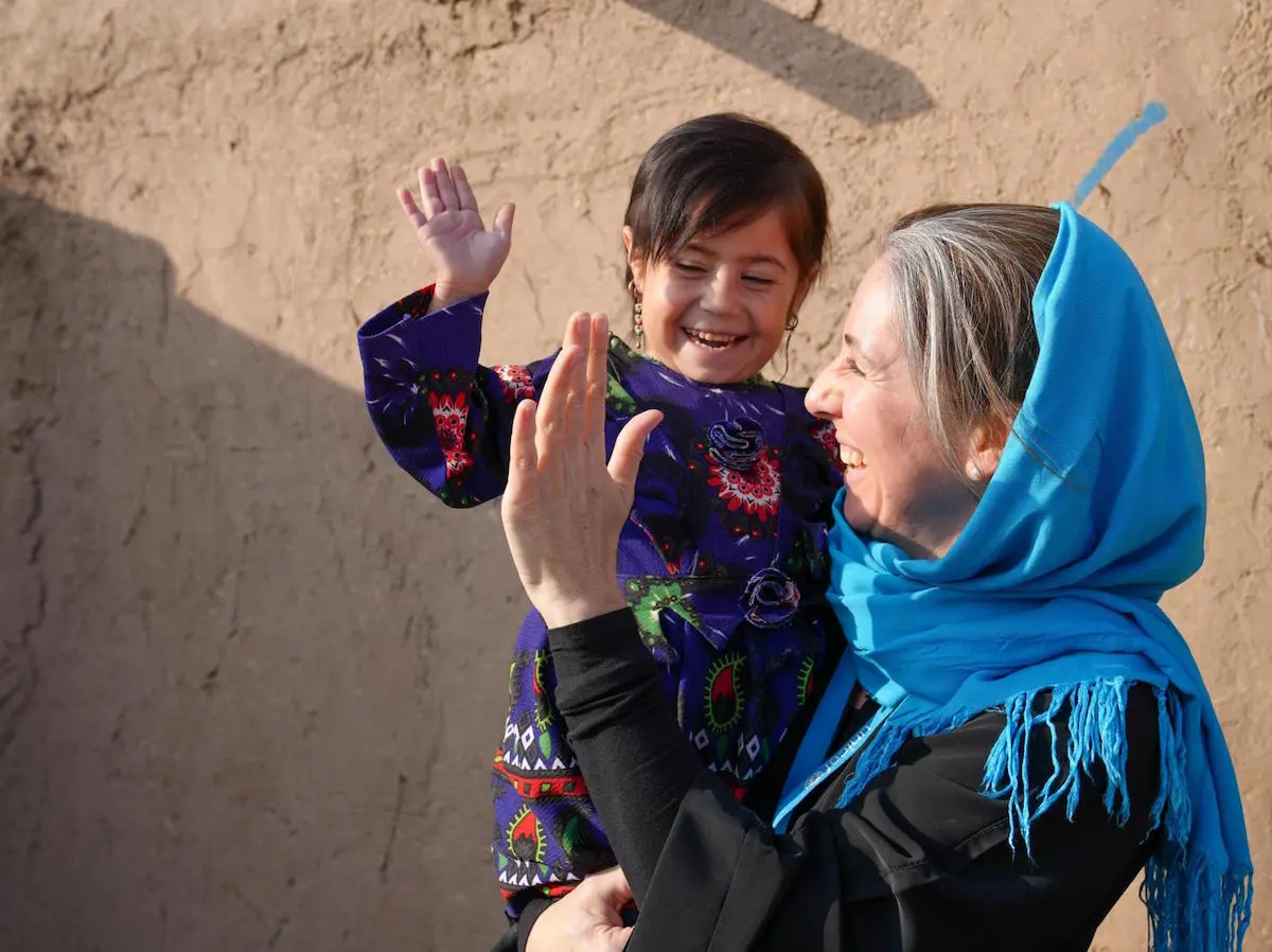 Adult Holding Child and High Fiving