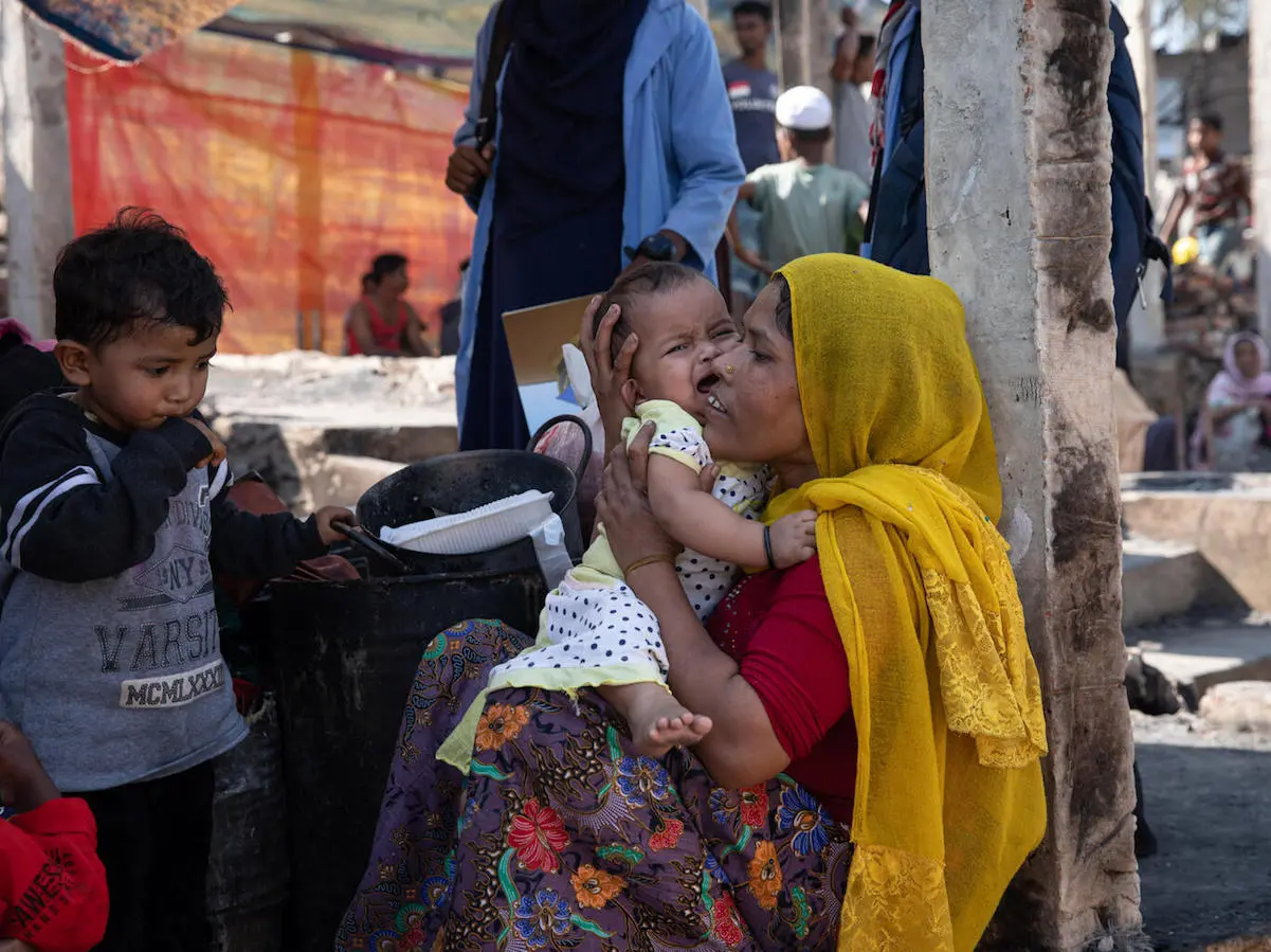 Rohingya refugee Tahrim consoles her infant daughter after their shelter was destroyed in a fire on January 9, 2022 in Cox's Bazar, Bangladesh.